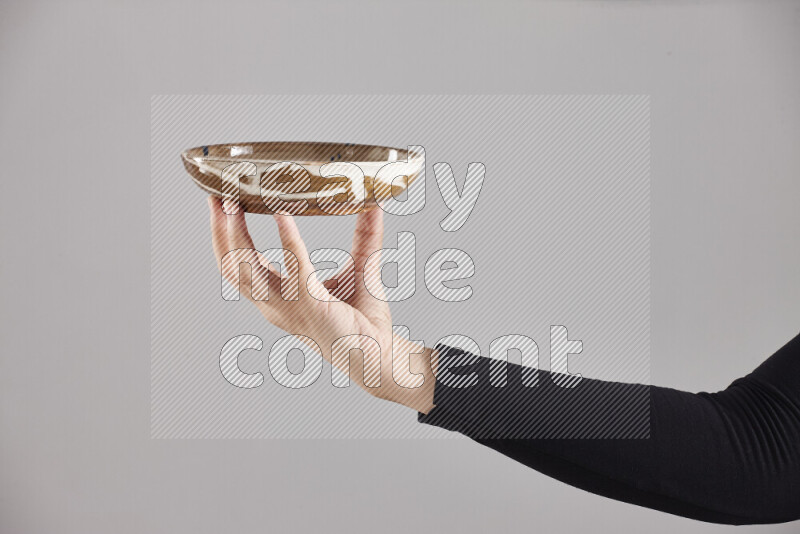 A woman in black abaya holding different pottery essentials in different positions