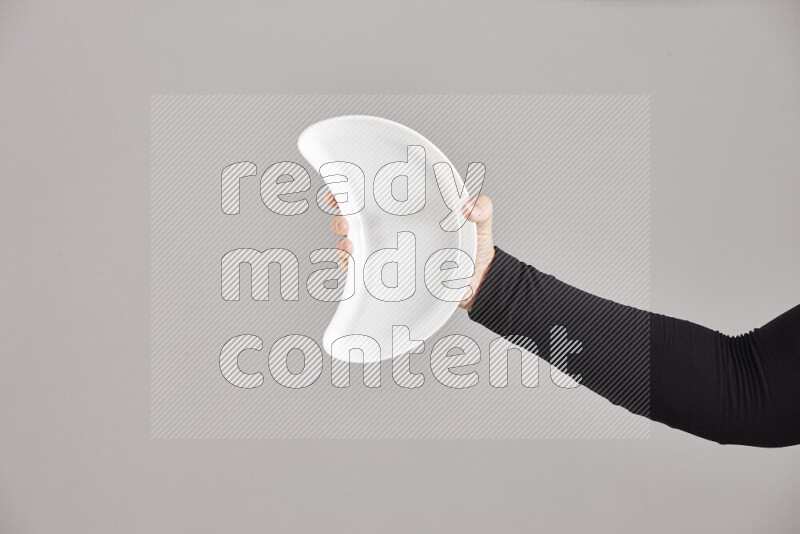 A woman in black abaya holding different pottery essentials in different positions