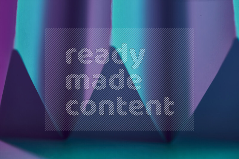 صورة مجردة مقربة تظهر طيات ورقية هندسية حادة بتدرجات اللون الأزرق والارجواني