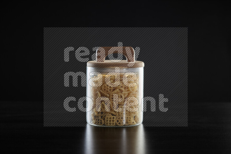 Snacks in a glass jar on black background