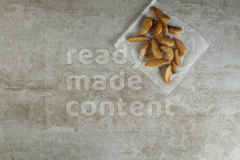 wedges potato on parchment paper on grey textured counter top