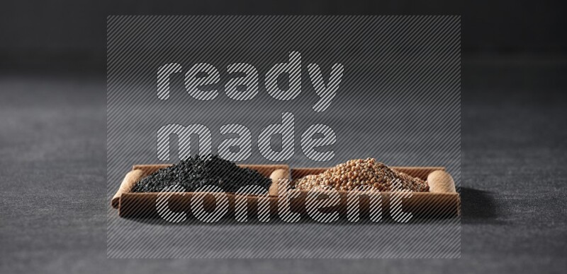 مربعان من أعواد القرفة ممتلئان بحبوب الخردل وحبة البركة السوداء علي خلفية سوداء