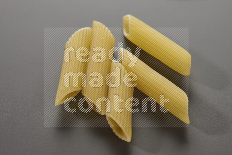 Penne pasta on grey background