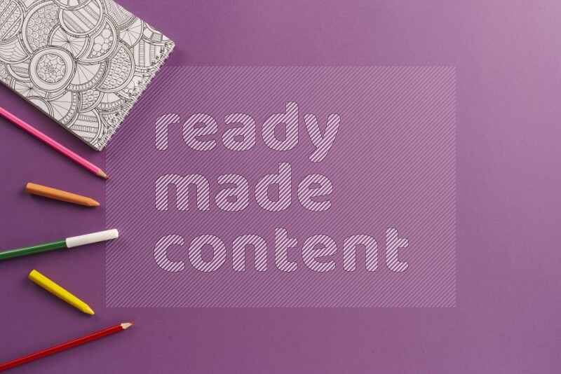 A coloring book with coloring pens on purple background