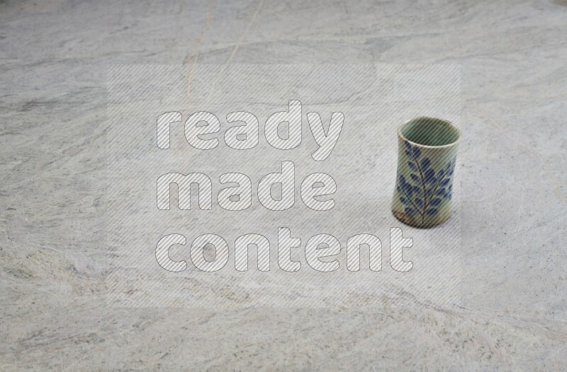 A multicolored pottery Cup on grey marble background