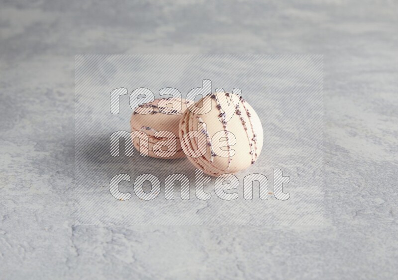 45º Shot of two pink orange blossom macarons  on white  marble background