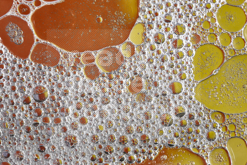 Close-ups of abstract soap bubbles and water droplets on orange and yellow background