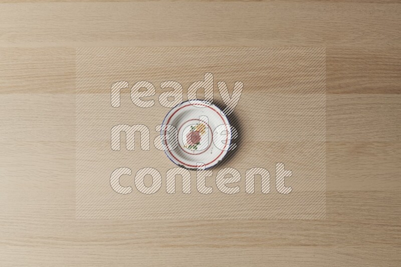 A vintage metal plate on light wooden background