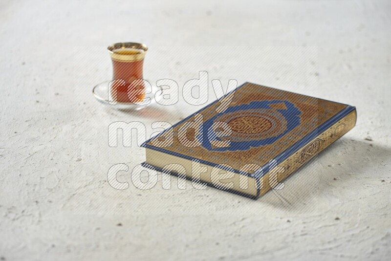 Quran with dates, prayer beads and different drinks all placed on textured white background