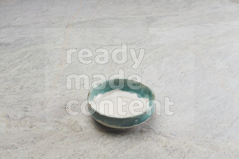 A multicolored pottery bowl on grey marble background