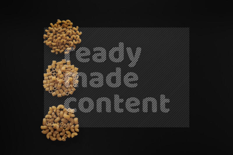 Different pasta types in 3 bunches on black background