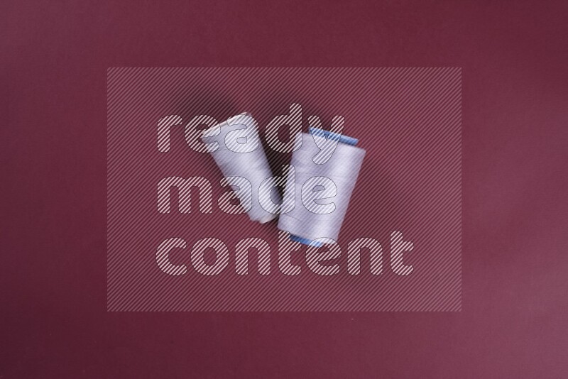 مجموعة من أدوات الخياطة والتفصيل رمادية اللون على خلفية حمراء