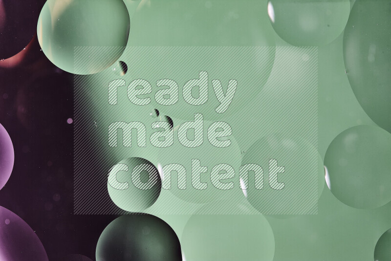 Close-ups of abstract oil bubbles on water surface in shades of green and pink