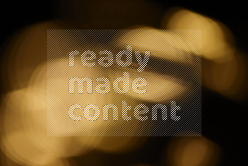 Light bulbs glowing against backdrop of golden bokeh