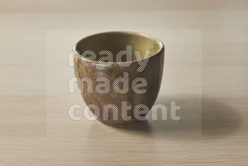 A multicolored pottery bowl on light wooden background