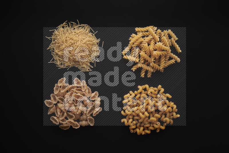 Different pasta types in bunches on black background