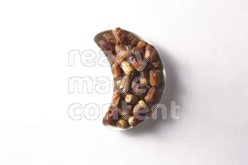 Dates in a crescent pottery plate on white background