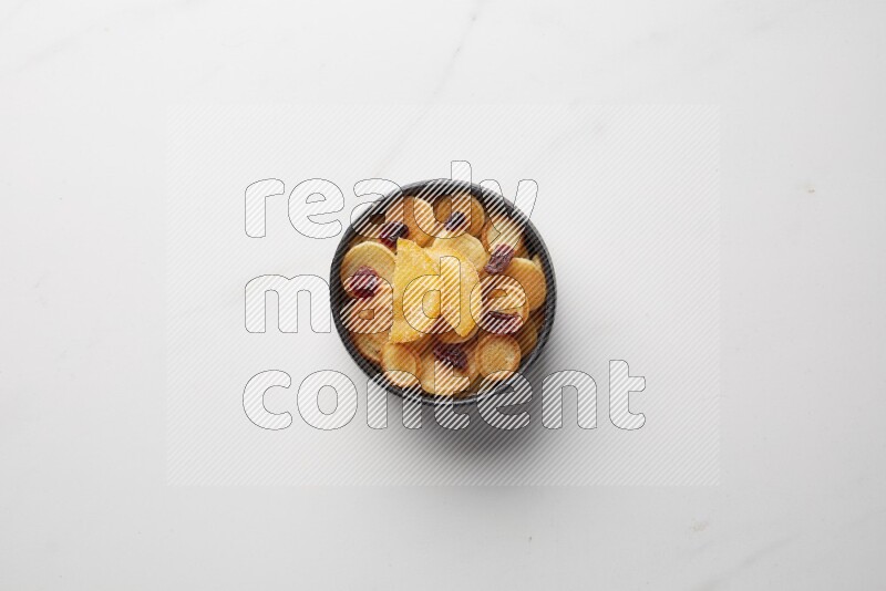 Top-view shot of orange candy cereal pancakes in a round bowl on white background