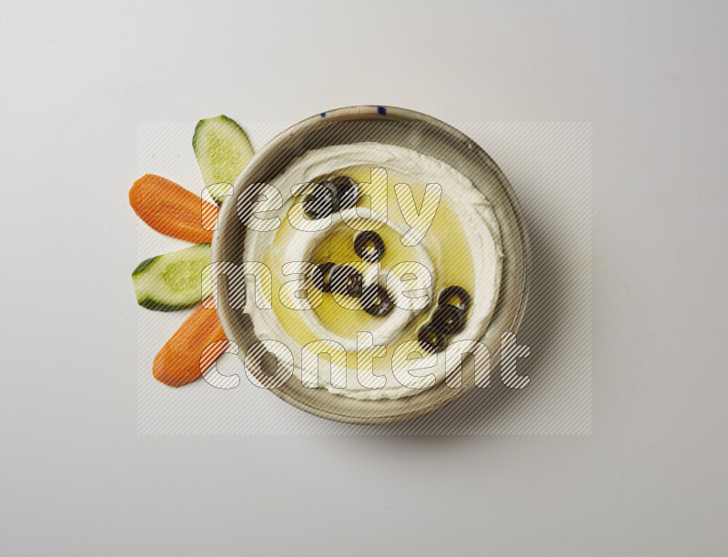 Lebnah garnished with sliced olives in a grey pottery plate on a white background