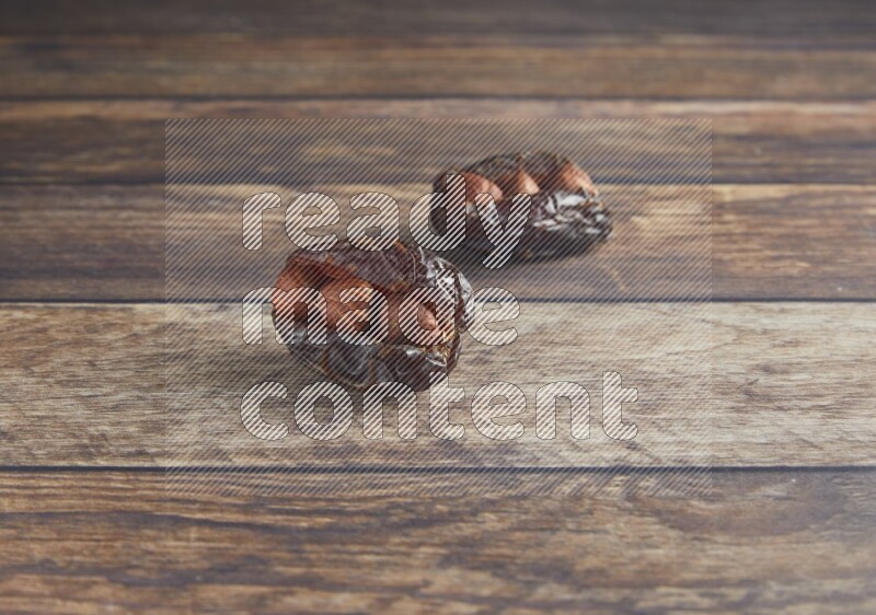 two hazelnut stuffed madjoul date on a wooden background