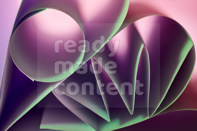 An artistic display of paper folds creating a harmonious blend of geometric shapes, highlighted by soft lighting in green and purple tones