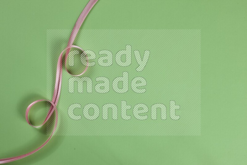 مجموعة من أدوات الخياطة والتفصيل زهرية اللون على خلفية خضراء