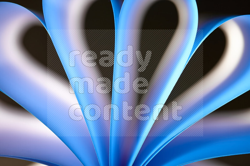 An abstract art piece displaying smooth curves in white and blue gradients created by colored light