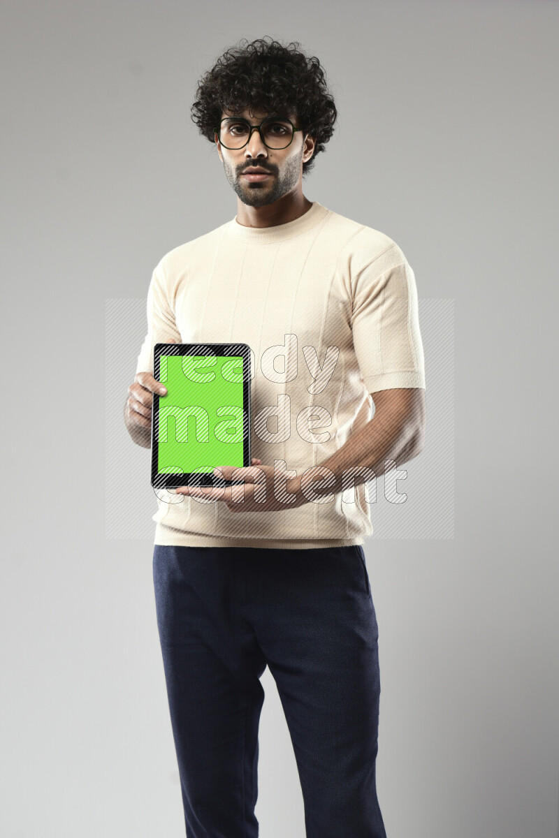 A man wearing casual standing and showing a tablet screen on white background