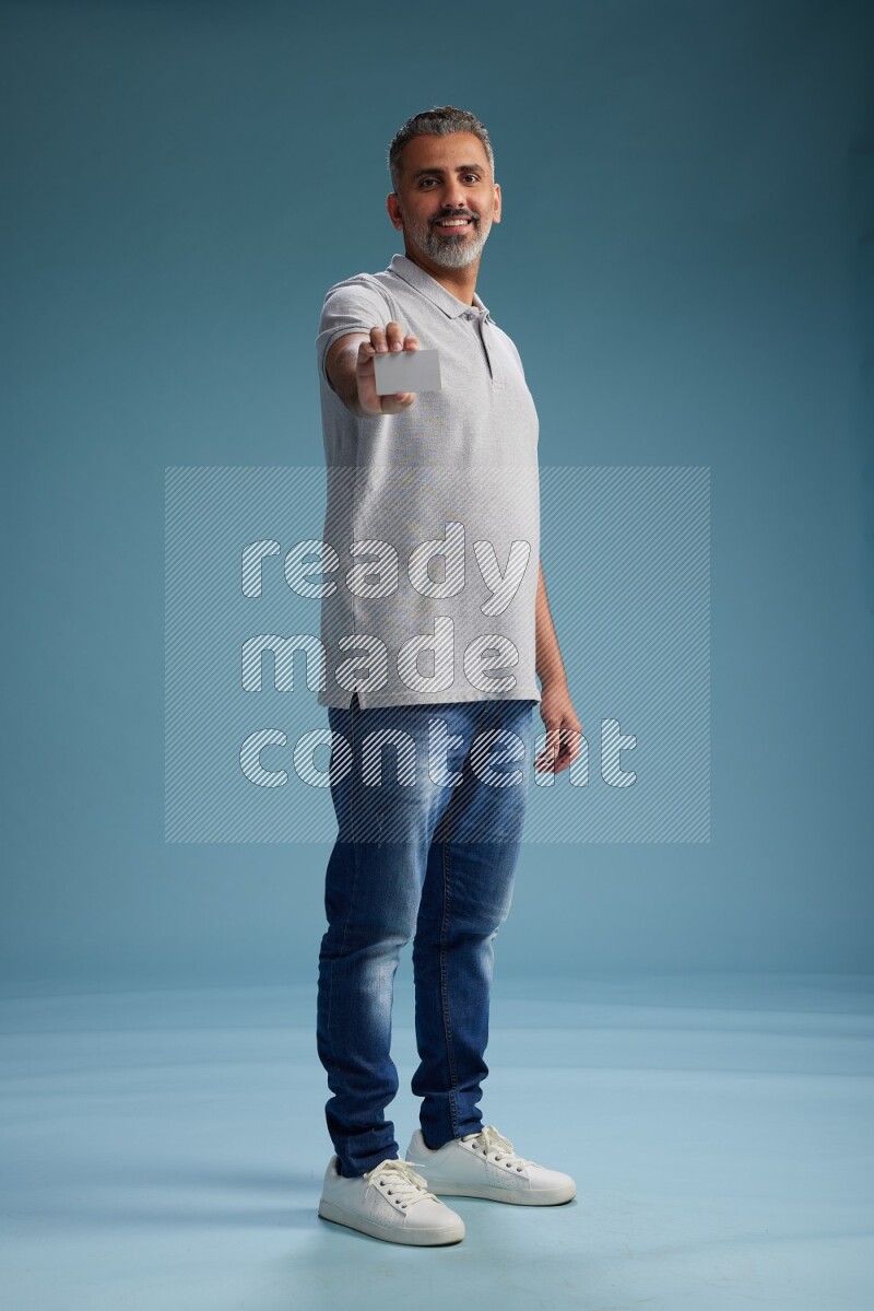 Man Standing holding ATM on blue background