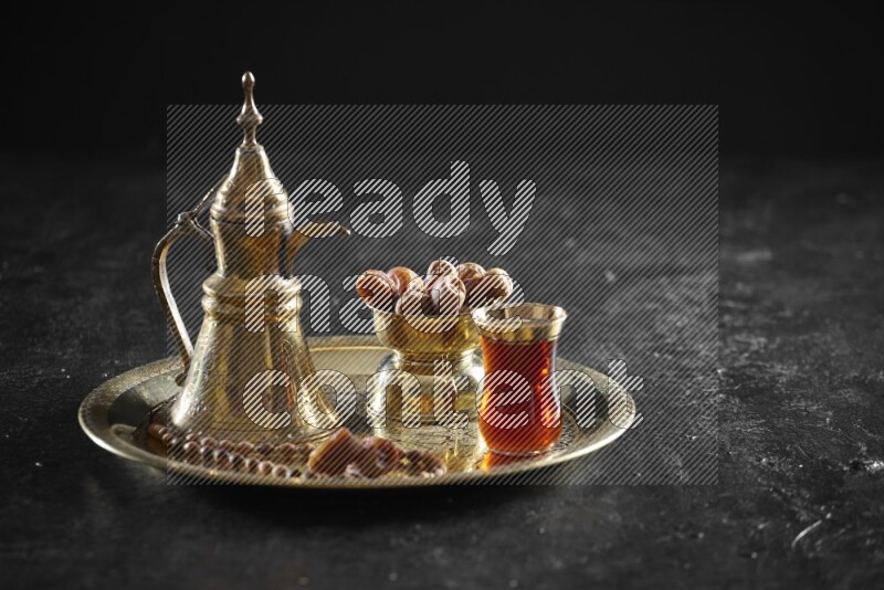 Dates with a drink on a metal tray in a dark setup