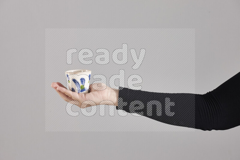A woman in black abaya holding different pottery essentials in different positions