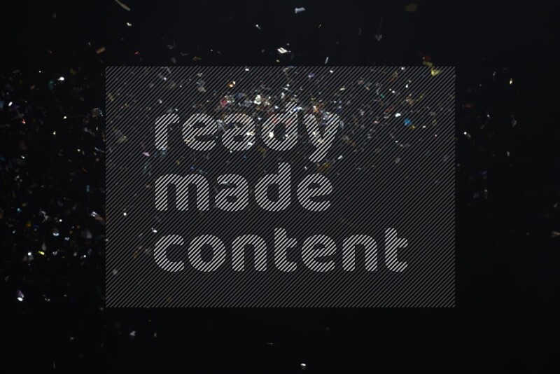 Falling multicolored confetti on black background