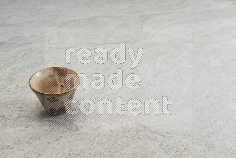 A multicolored pottery Cup on grey marble background