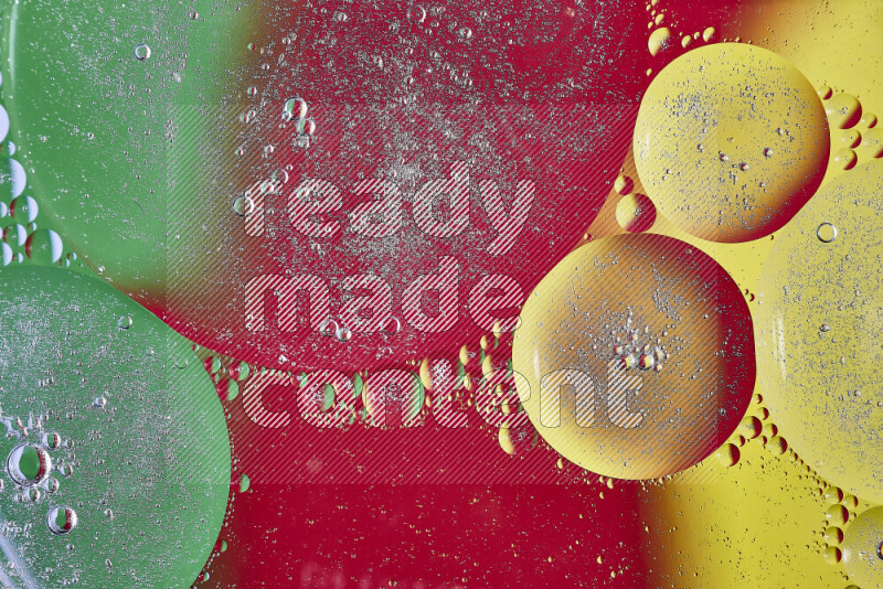Close-ups of abstract oil bubbles on water surface in shades of yellow, green and red