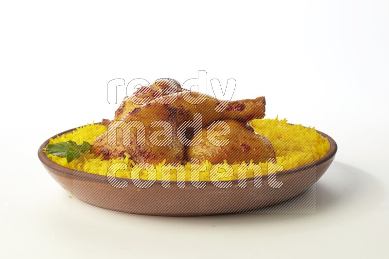 yellow basmati Rice with kabsa chicken pieces on a pottery plate direct on white background