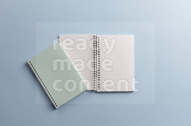 A blue notebook with different school supplies on blue background