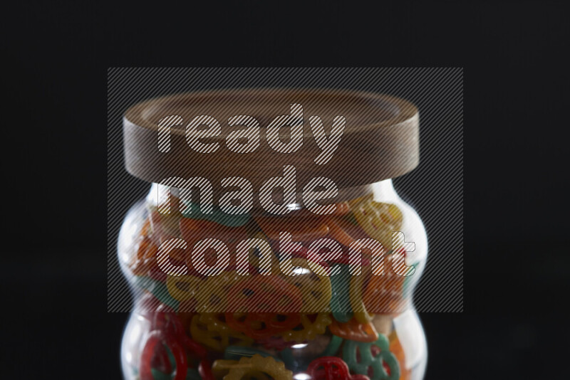 Snacks in a glass jar on black background