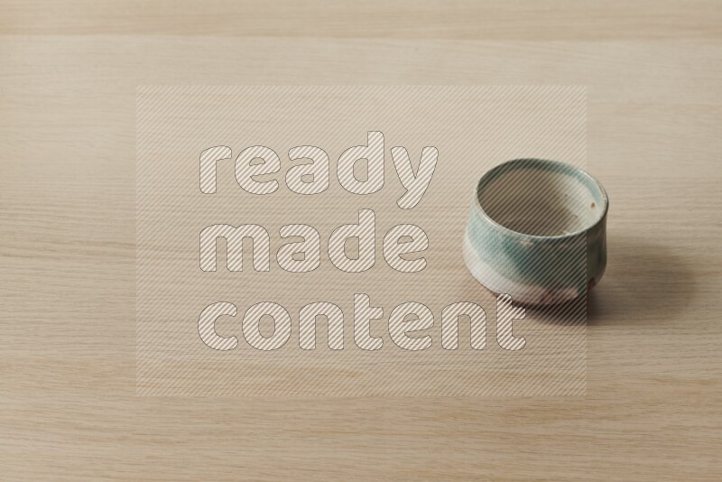 A multicolored pottery bowl on light wooden background