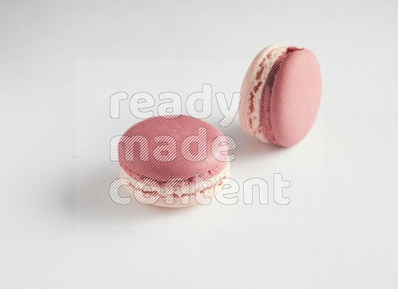45º Shot of two Pink Litchi Raspberry macarons on white background