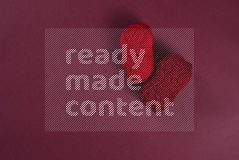 مجموعة من أدوات الخياطة والتفصيل حمراء اللون على خلفية حمراء