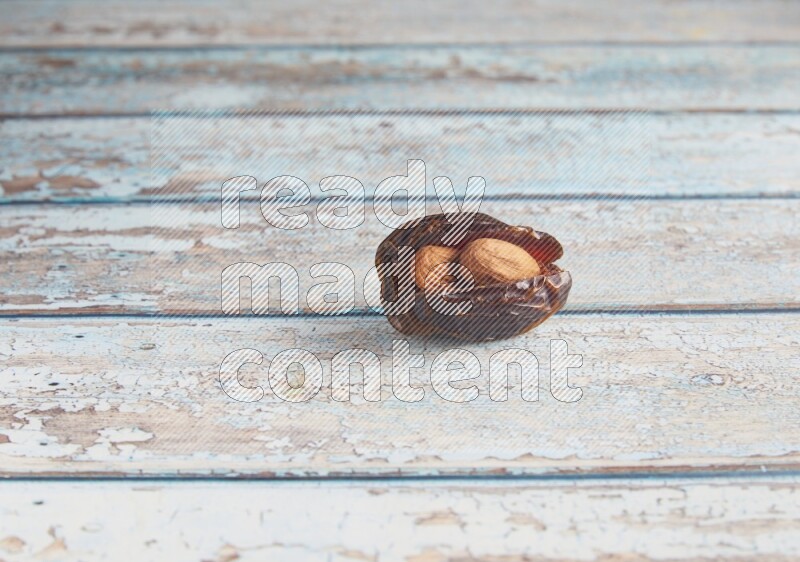 almond stuffed madjoul date on a light blue wooden background