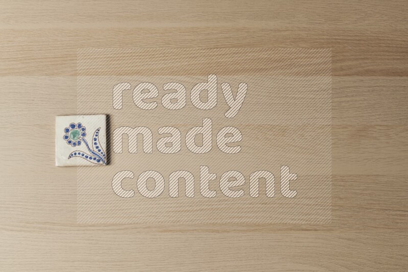 A decorative pottery coaster on light wooden background