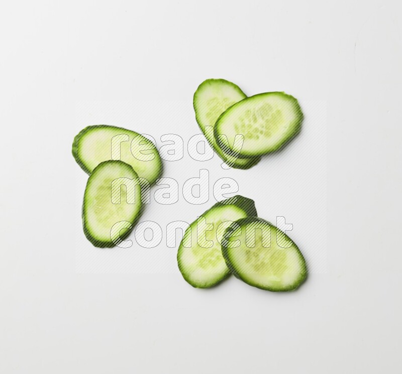 Multiple cucumber slices on white background