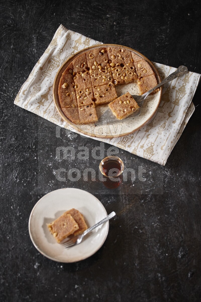 Basbousa with tea in a dark setup