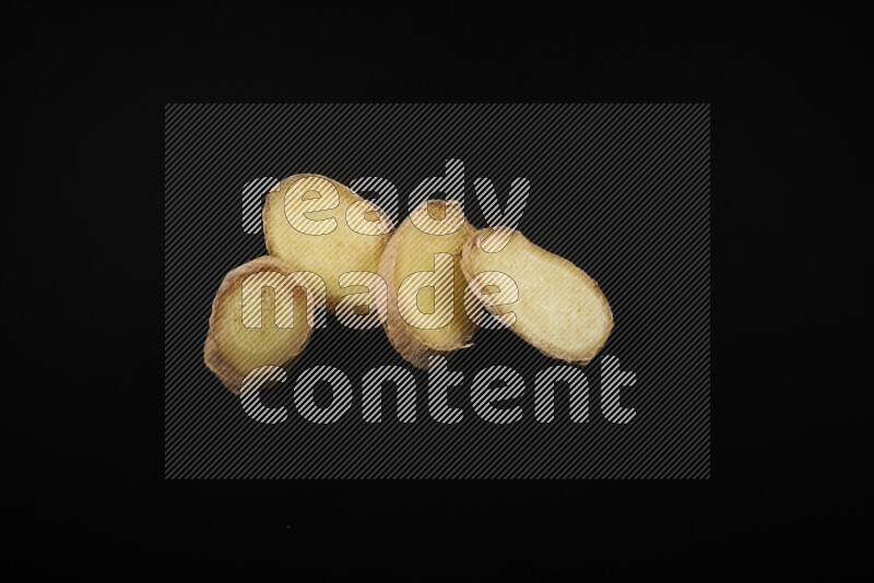 Fresh ginger slices on black background