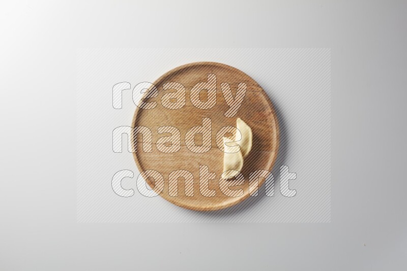Two Sambosas on a wooden round plate on a white background