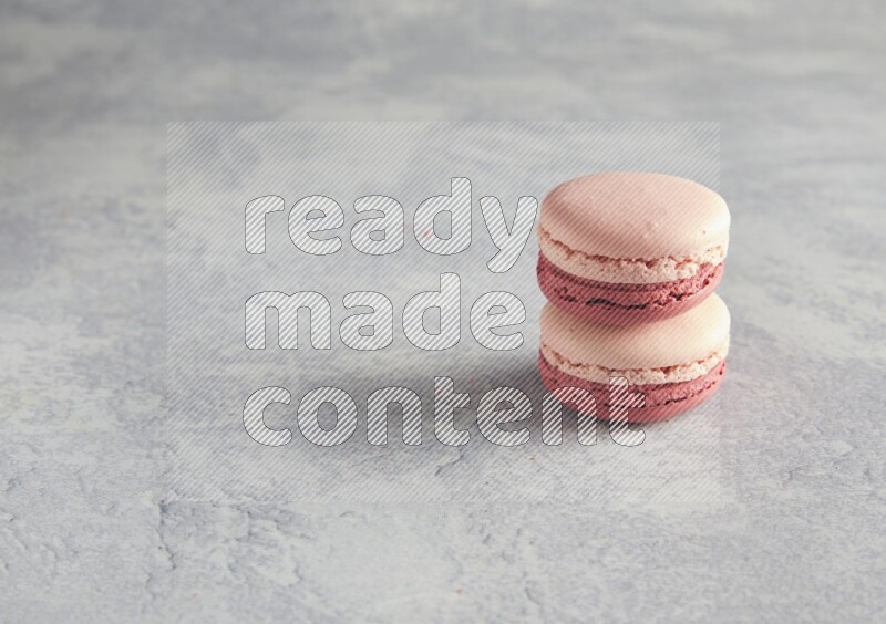 45º Shot of two Pink Litchi Raspberry macarons  on white  marble background