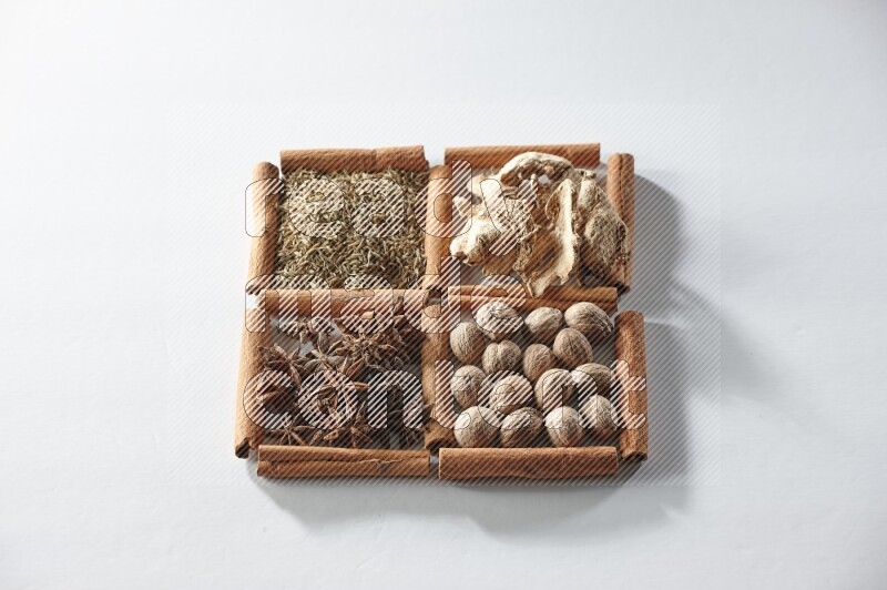 4 squares of cinnamon sticks full of star anise, ginger, cumin and nutmeg on white flooring