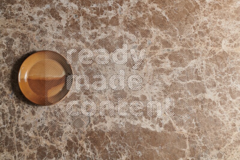 A multicolored pottery plate on beige marble background