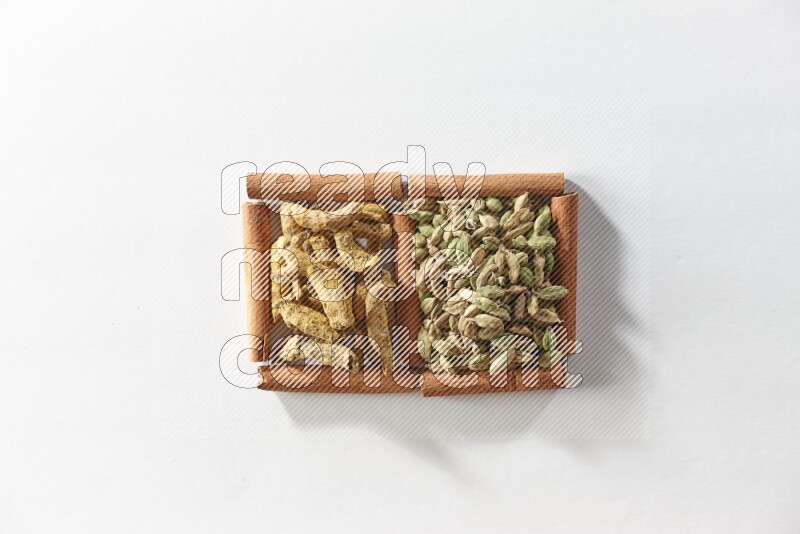 2 squares of cinnamon sticks full of cardamom and turmeric fingers on white flooring